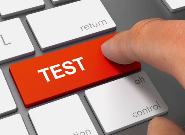 A finger pressing a test key during testing and iteration